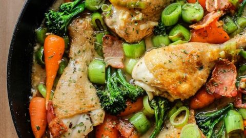 white wine braised chicken and veggies in a cast iron pan