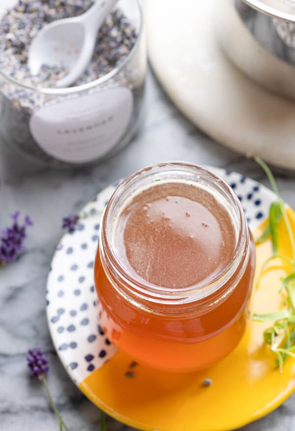 Lavender Simple Syrup on a small plate with fresh and dried lavender surrounding