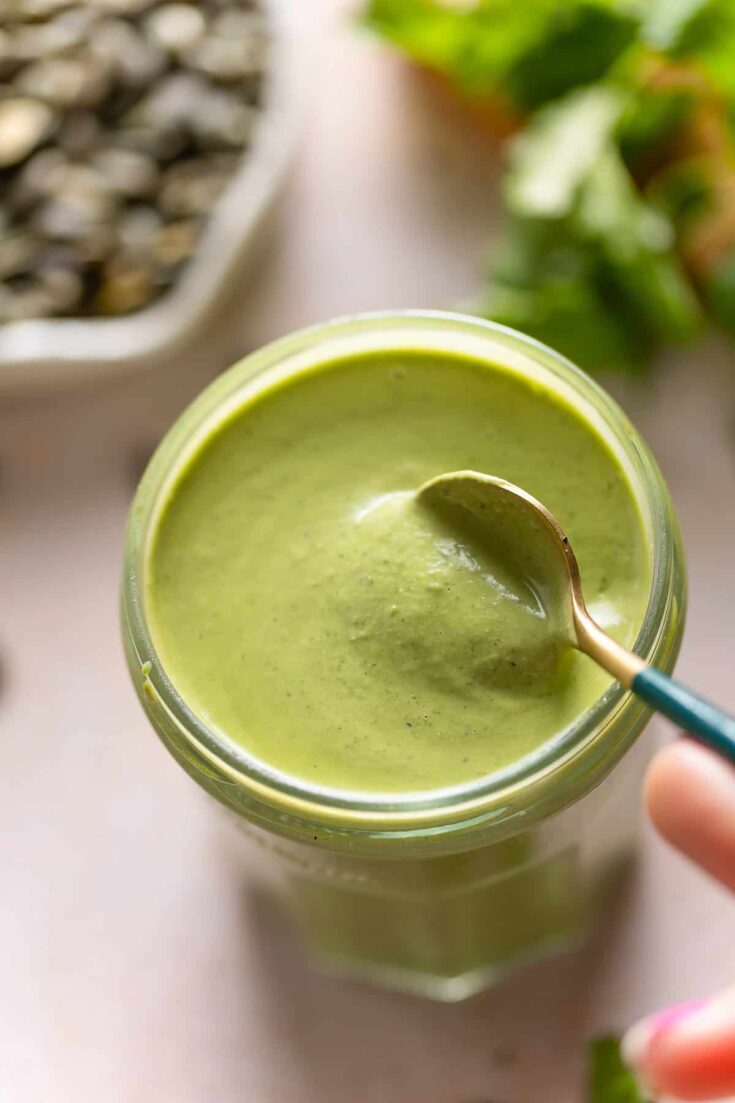 Cilantro Pepita Dressing in a jar with a spoon