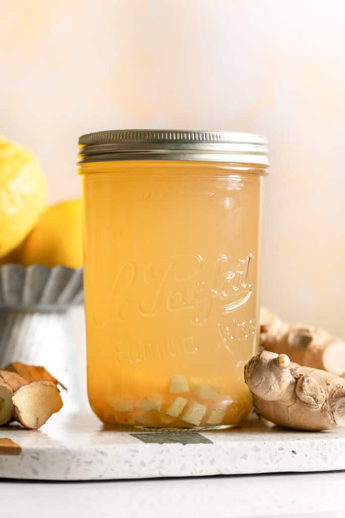 a quart-sized jar full of homemade switchel with ginger slices inside