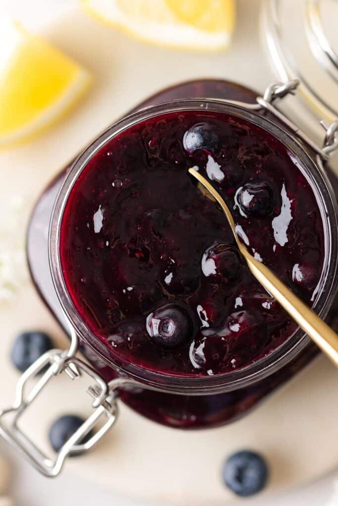 homemade blueberry pie filling for cakes and pies in a jar with a spoon 