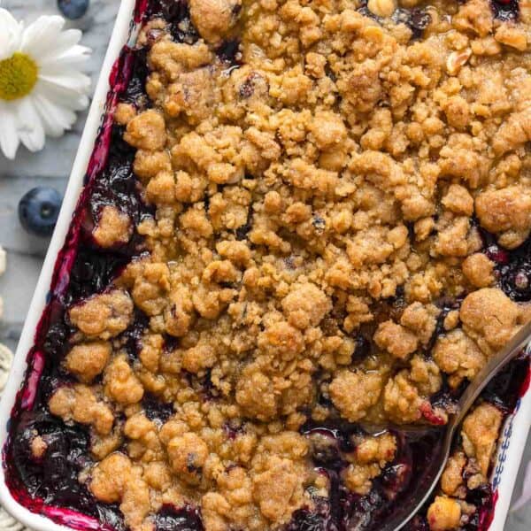 Gluten Free Blueberry Crumble in a baking dish with a serving spoon inside