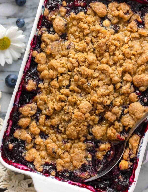 Gluten Free Blueberry Crumble in a baking dish with a serving spoon inside