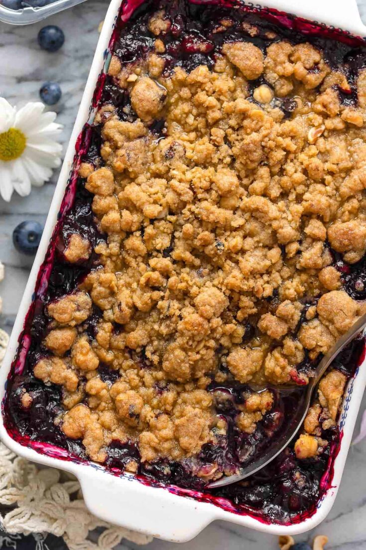 Gluten Free Blueberry Crumble in a baking dish with a serving spoon inside