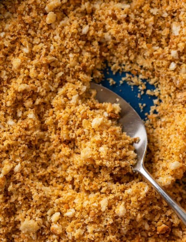 homemade gluten free breadcrumbs in a bowl with a spoon scooping some of the breadcrumbs up