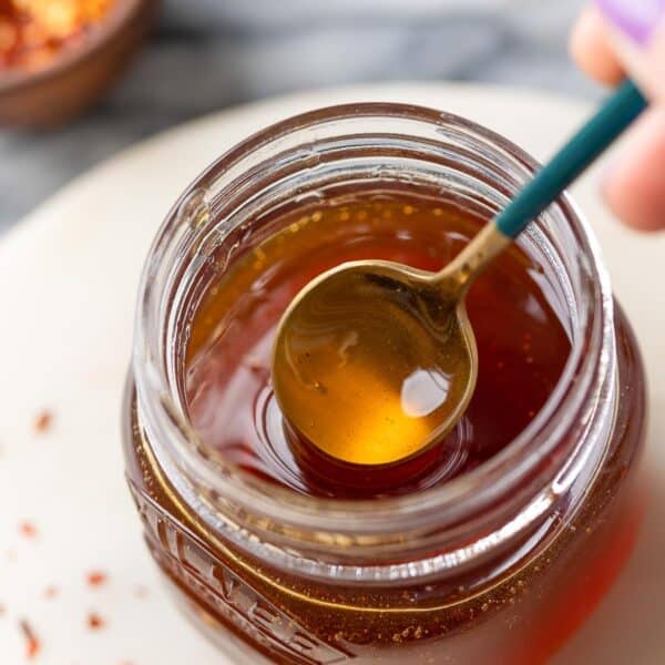 hot honey in a jar stirred by a spoon