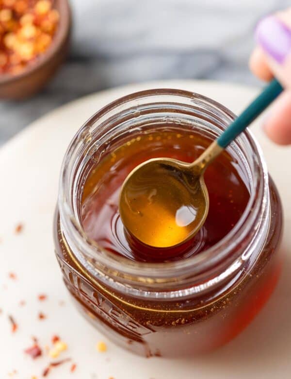 hot honey in a jar stirred by a spoon