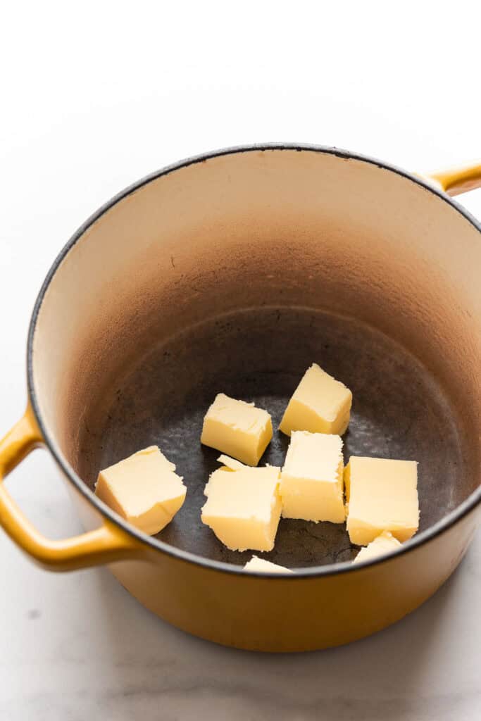 butter cubes in a big pot with text: 'melt butter, salt & sugar'