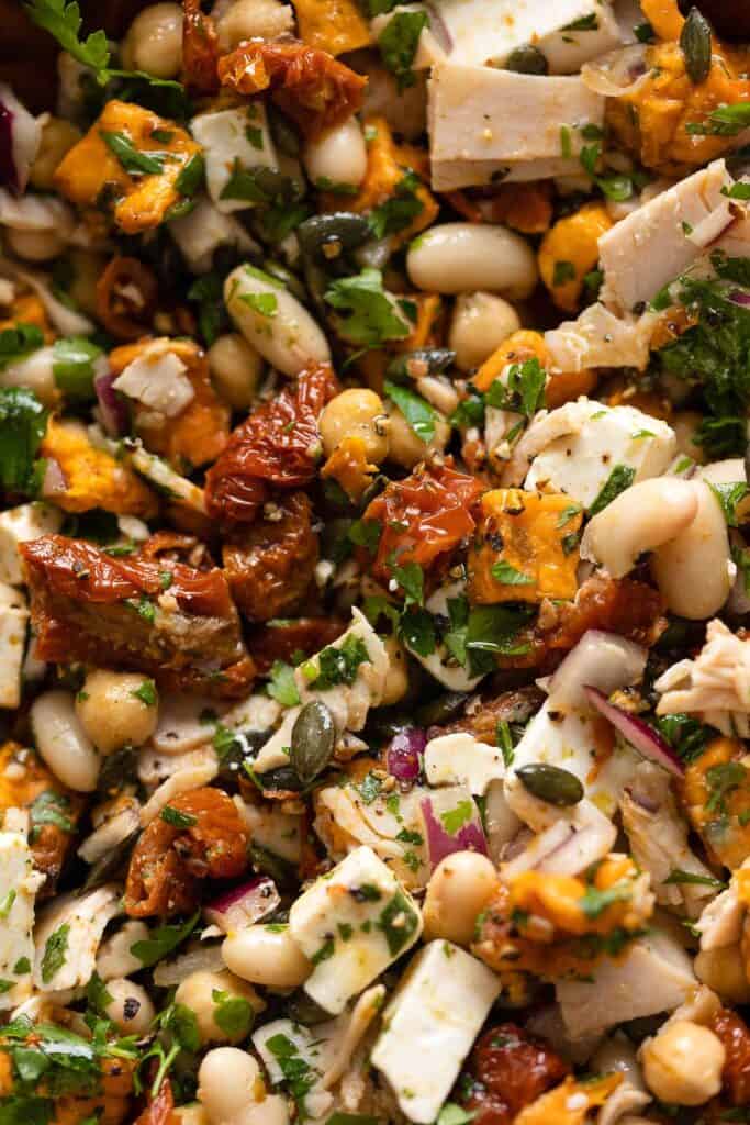 a mediterranean dense bean salad made up of white beans, fresh parsley, turkey slices, feta, sun-dried tomato and sweet potato tossed in a lemon vinaigrette 