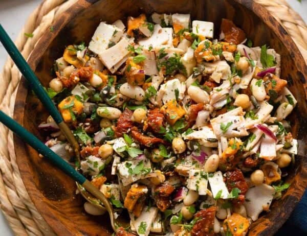 a mediterranean dense bean salad made up of white beans, fresh parsley, turkey slices, feta, sun-dried tomato and sweet potato tossed in a lemon vinaigrette