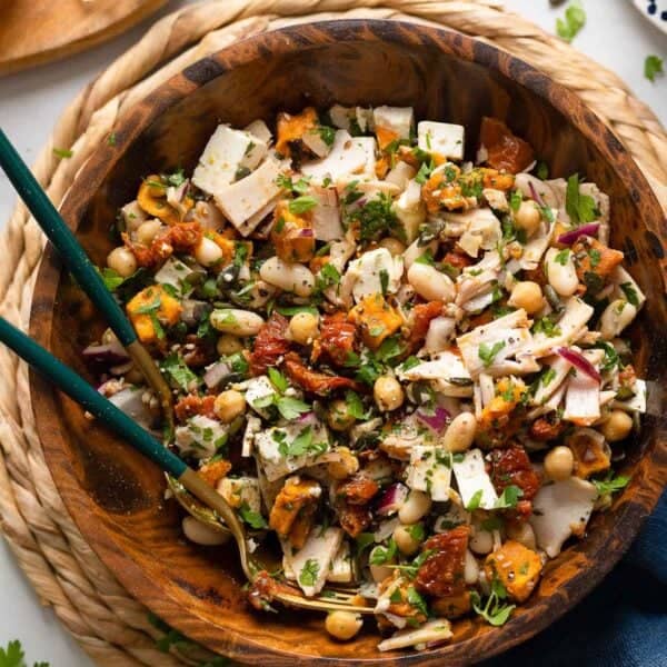 a mediterranean dense bean salad made up of white beans, fresh parsley, turkey slices, feta, sun-dried tomato and sweet potato tossed in a lemon vinaigrette