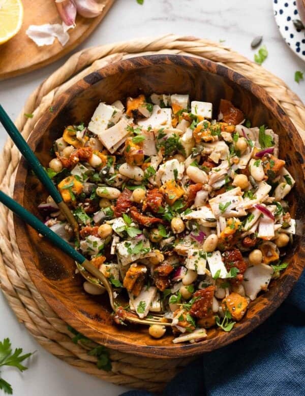 a mediterranean dense bean salad made up of white beans, fresh parsley, turkey slices, feta, sun-dried tomato and sweet potato tossed in a lemon vinaigrette