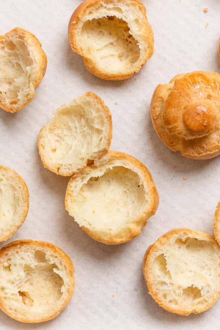 gluten free choux buns cut in half on a baking sheet