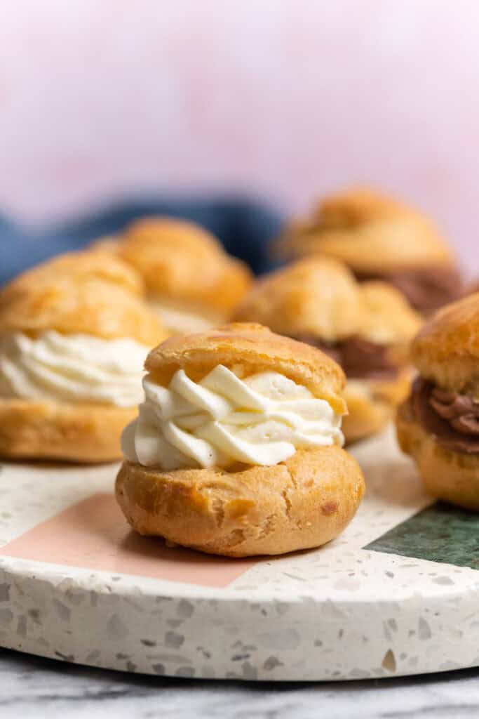 gluten free cream puffs with mascarpone whipped cream, some chocolate cream filled cream puffs in the back