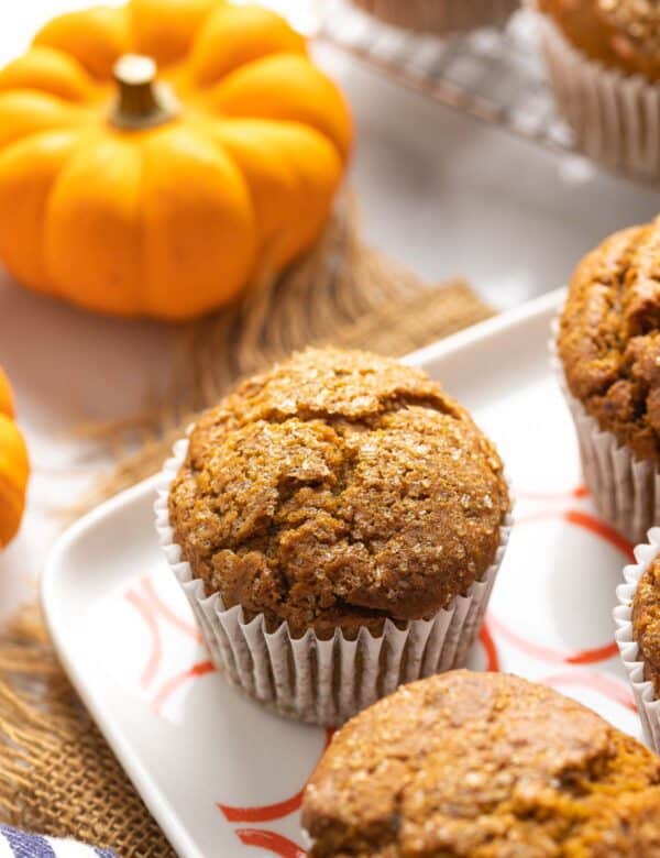 Gluten Free Pumpkin Muffins on a serving plate with a little pumpkin