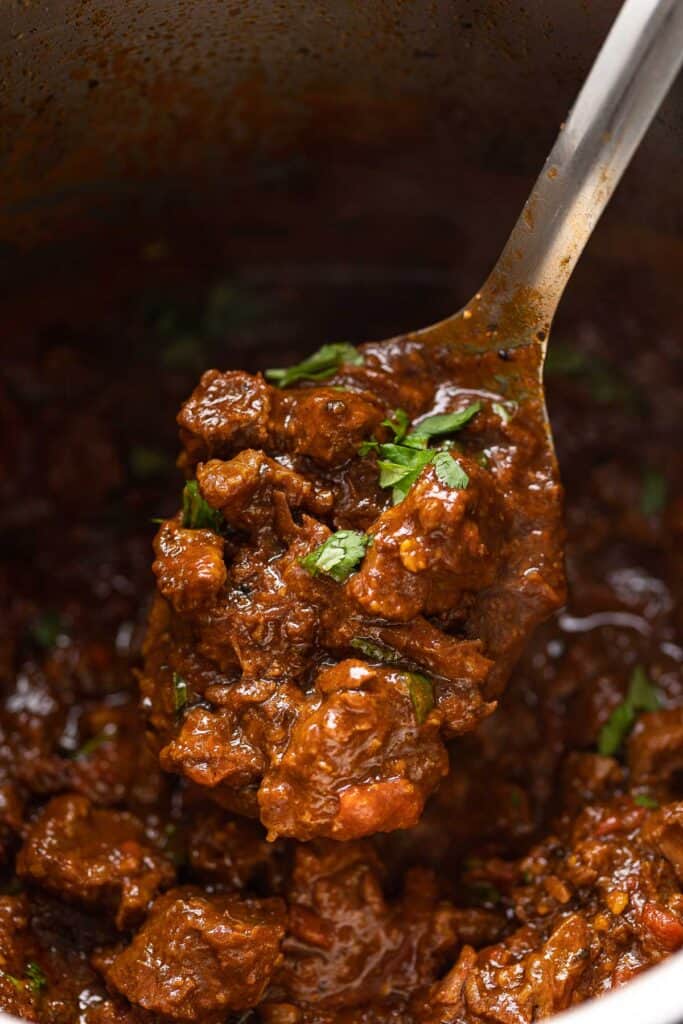 a serving spoon full of extra saucy carne desmechada made in the instant pot 