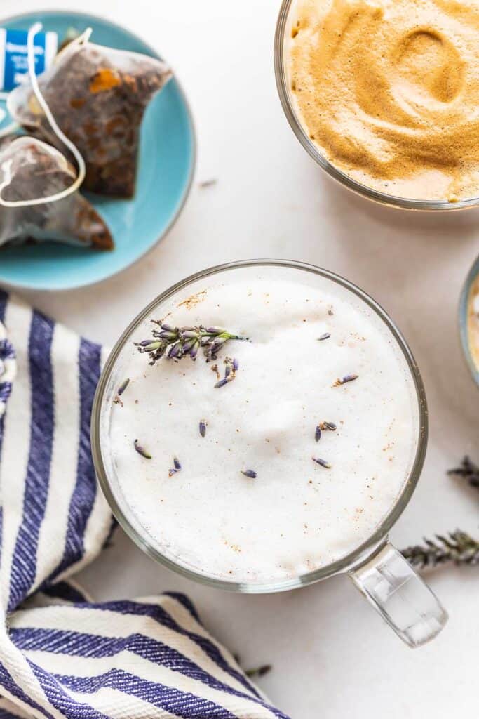 a homemade London fog latte with a sprig of fresh lavender on top and the used tea bags on the side