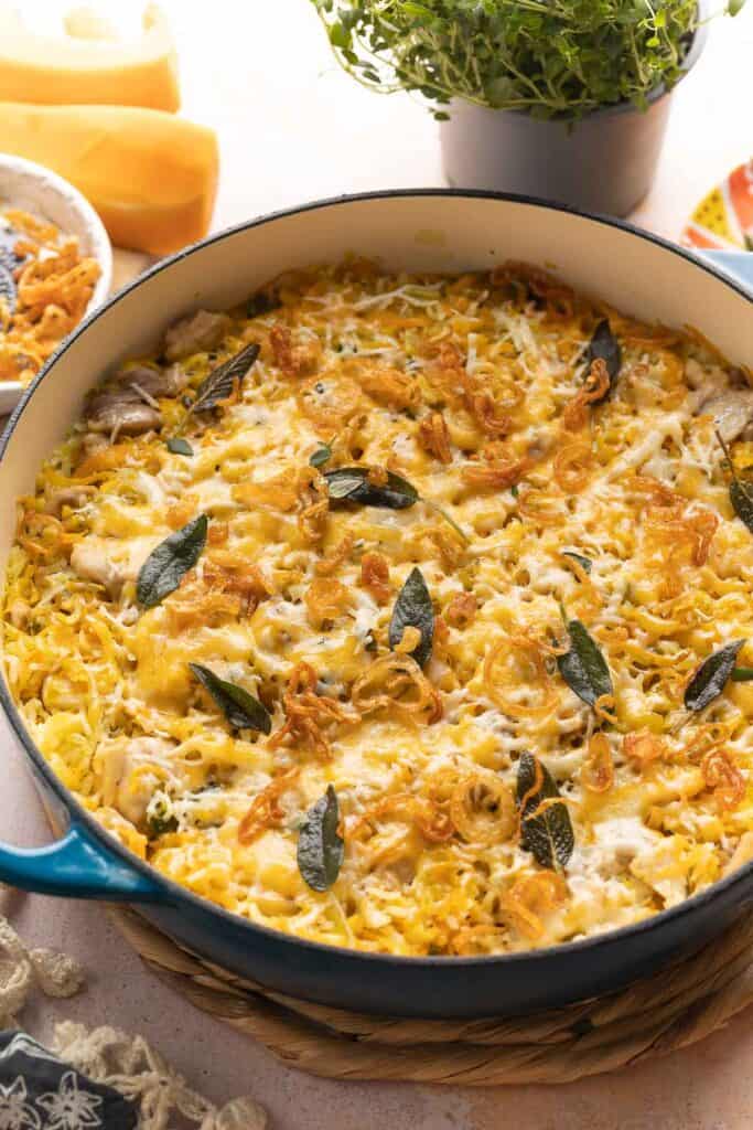 One pot Butternut Squash Chicken & Rice in a casserole dish topped with fried sage and fried shallots