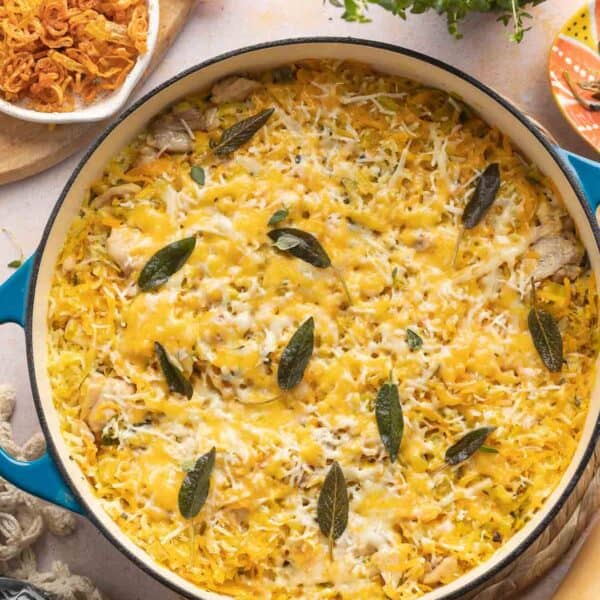 butternut squash chicken & rice with cheese in a casserole dish with crispy sage on top