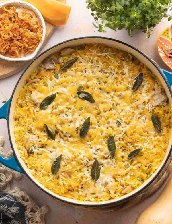 butternut squash chicken & rice with cheese in a casserole dish with crispy sage on top