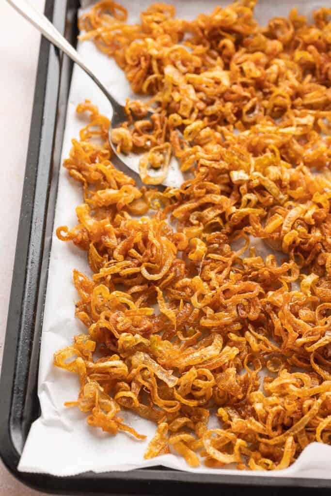 Crispy Fried Shallots on a baking sheet with a spoon