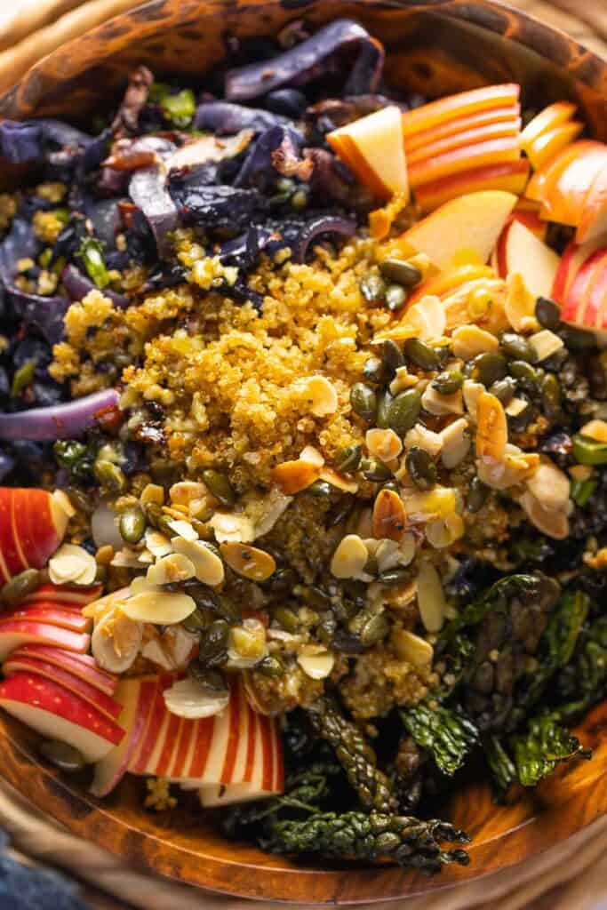 A salad made with Roasted Cabbage and Kale, Crispy Quinoa, apples, fried halloumi, pumpkin seeds and almond slices