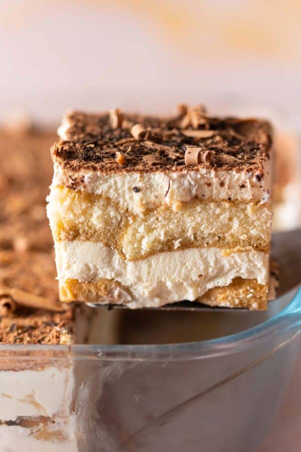 a gluten free tiramisu slice held up on a serving utentsil