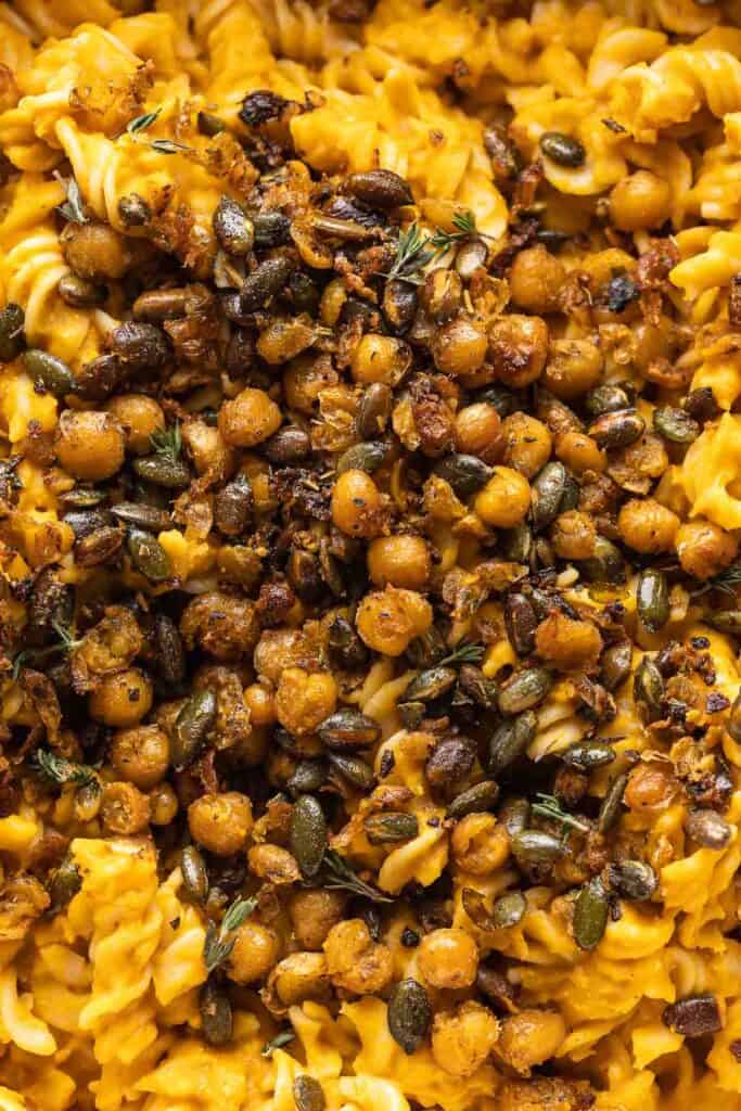 Fried chickpeas and pepitas with fresh thyme leaves over a bed of roasted butternut squash pasta.