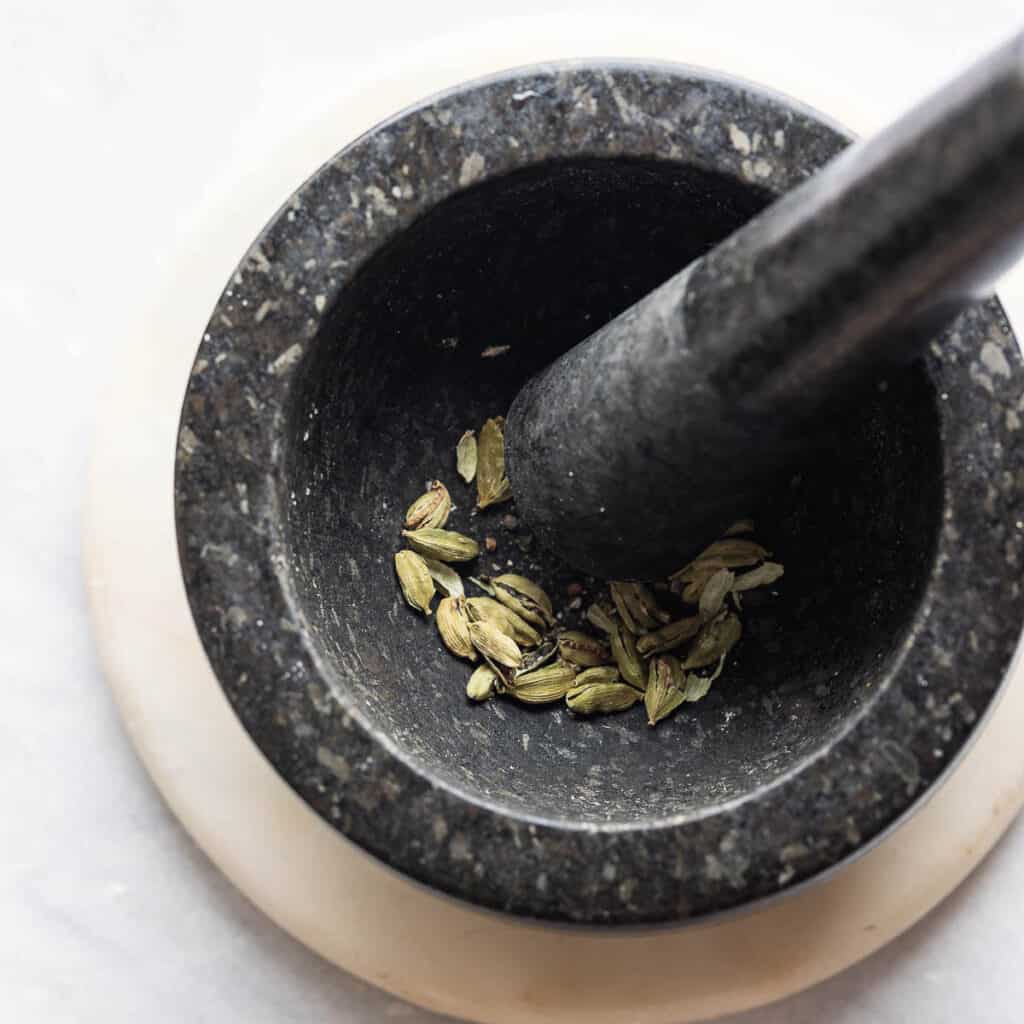 Cardamom pods in a mortar and pestle.