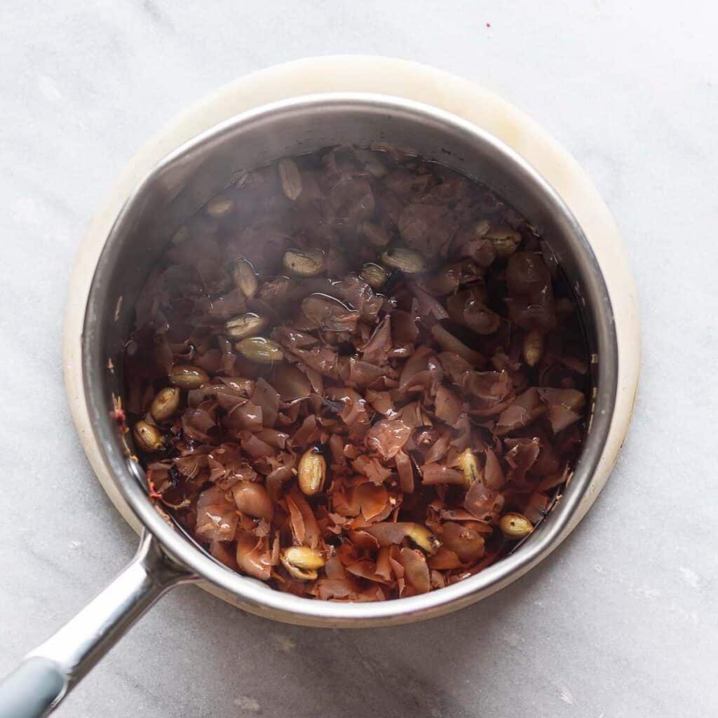 A simmering saucepan full of ingredients for a homemade rose syrup.